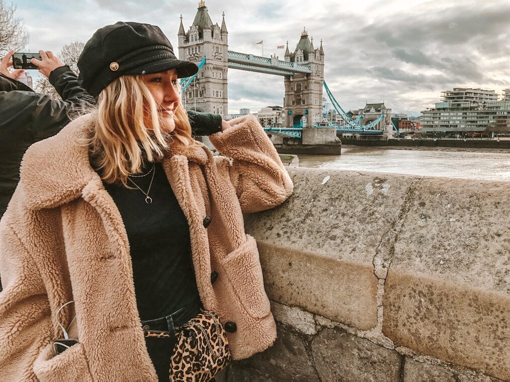 Woman poses by Tower Bridge in London, England.